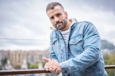 Kot ceketli çekici bir gencin portresi.