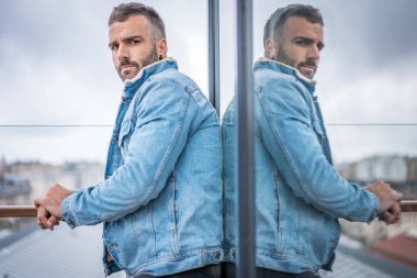 Kot ceketli çekici bir gencin portresi.