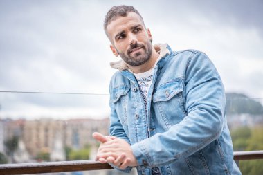 Kot ceketli çekici bir gencin portresi.