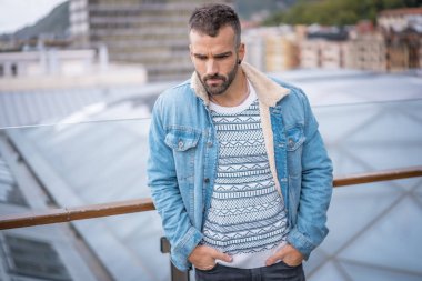 Kot ceketli çekici bir gencin portresi.