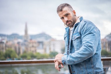 Kot ceketli çekici bir gencin portresi.