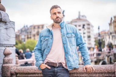 Kot ceketli çekici bir gencin portresi.