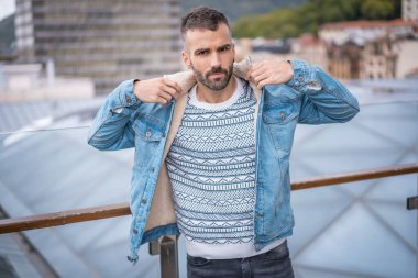 Kot ceketli çekici bir gencin portresi.