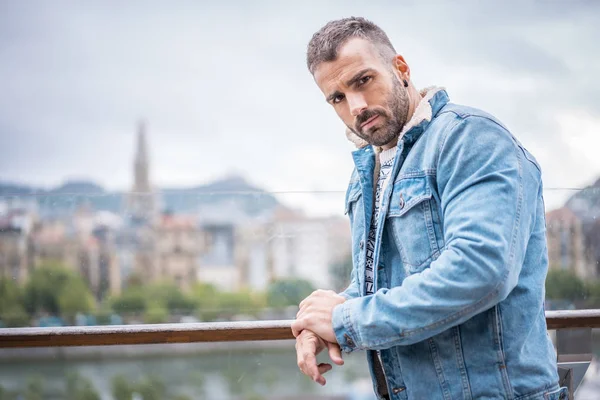 Kot ceketli çekici bir gencin portresi.