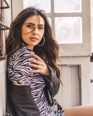 Kalitesiz iç mekanlarda çekici genç bir kadının moda portresi.