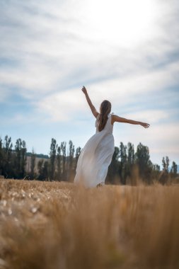 Kırsal kesimde beyaz elbise giyen güzel bir genç kadının portresi.