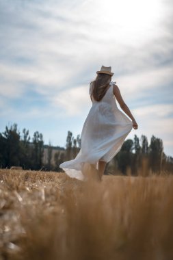 Kırsal kesimde beyaz elbise giyen güzel bir genç kadının portresi.