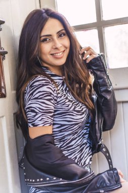 Kalitesiz iç mekanlarda çekici genç bir kadının moda portresi.