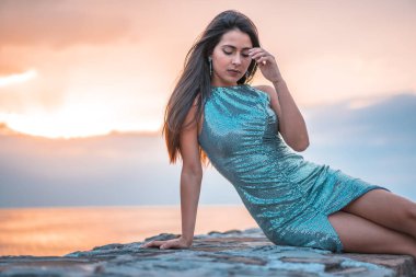 Zarautz 'daki çekici genç kadının moda portresi, gün batımı manzarası.