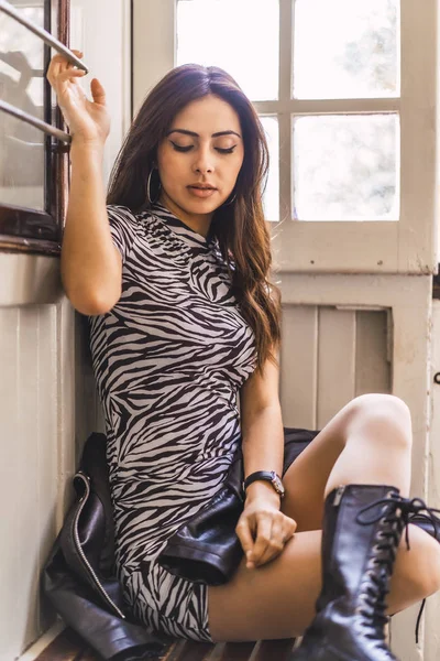 fashion portrait of attractive young woman in shabby interior