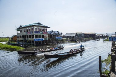 Inle Lake, Myanmar - Spring, 2018: a woman with the crop covered for her home in a boat