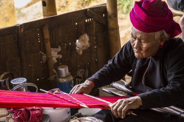 Inle Lake, Myanmar - Spring, 2018:  a local old woman with the sewing machine preparing the traditional red suit