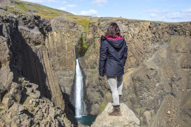 Hengifoss 'a bakan genç bir kadın, İzlanda' nın en uzun üçüncü şelalesi.