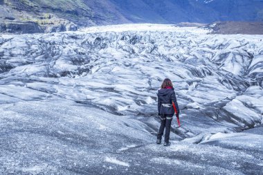 İzlanda 'daki Svinafellsjokull buzulunda yürüyen genç bir kız.