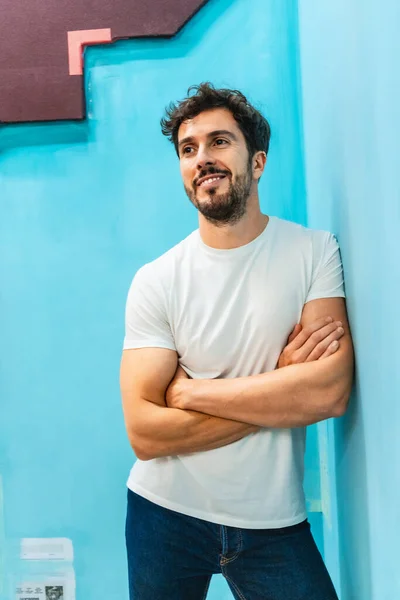 Street Style, a young Caucasian man leaning against a blue wall
