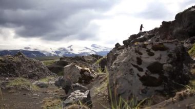 Genç bir kadın, İzlanda 'daki karada yüzen muhteşem manzaralara bakıyor. İzlanda