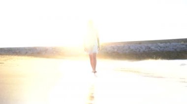 Yaşam tarzı, genç bir Kafkas esmer kumsalda gün batımında geziniyor.