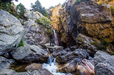 Aragonese Pirenesi 'ndeki Baos de Panticosa' nın küçük bir şelalesinde genç bir kadın. İspanya, dikey fotoğraf