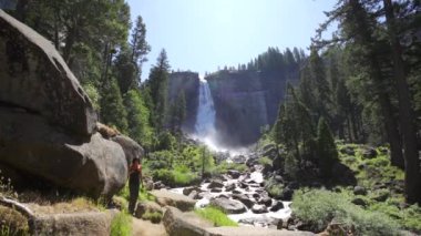 Şelaleye bakan, Vernal Falls 'ta siyah tişörtlü esmer bir turist. Kaliforniya, Birleşik Devletler