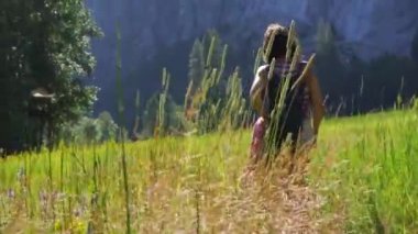Yosemite Ulusal Parkı 'nın çayırlarında gezinen genç bir kadın. Kaliforniya, Birleşik Devletler