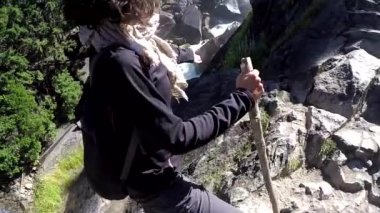 Yosemite Ulusal Parkı 'ndaki Vernal Falls şelalesine bakan genç bir kadın. Kaliforniya, Birleşik Devletler