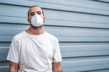 Maskeli ve beyaz gömlekli, kopyala yapıştır alanı olan genç bir adam. Sağlık acil durumu, salgın Covid-19