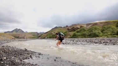 Landmannalaugar, İzlanda 'dan 54 km uzaklıktaki donmuş bir nehri geçen genç bir turist.