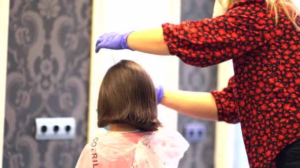 マスクと手袋を持つ美容師はさみで女の子の髪を切断します Covid 19パンデミックにおける美容師のためのセキュリティ対策の再開 — ストック動画