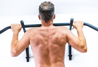 Hasta barfiks çekiyor. Covid-19 salgınında fizyoterapistlerin güvenlik önlemleriyle tekrar açılacak. Osteopati, tedavi edici kiromasaj.