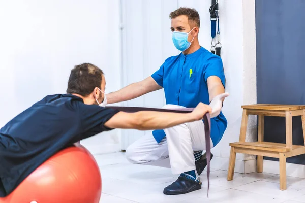 Physiotherapeut Mit Maske Und Ein Patient Machen Übungen Mit Einem — Stockfoto