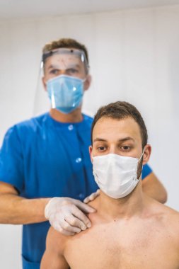 Bir hastaya köprücük kemiği masajı yapmak. Koronavirüs salgını için koruyucu önlemlerle fizik tedavi, COVID-19. Osteopati, tedavi edici kiromasaj.
