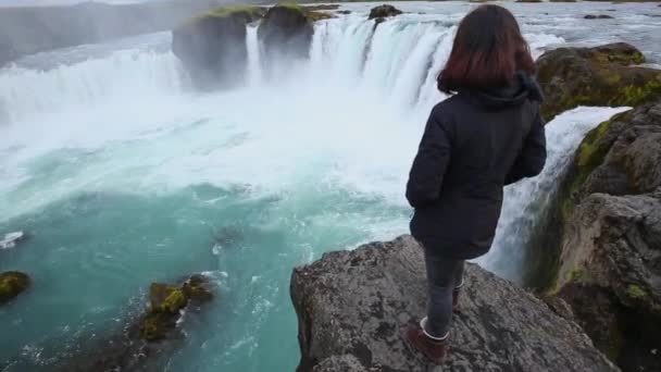 Μια Νεαρή Μελαχρινή Κοιτάζει Από Ψηλά Στον Καταρράκτη Godafoss Ισλανδία — Αρχείο Βίντεο