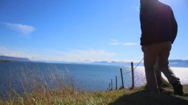 Olafsfjordur kıyısında yürüyen kadın ve erkek. İzlanda