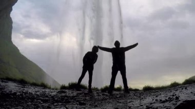 İnanılmaz Seljalandsfoss şelalesinin içinde bir çift. İzlanda
