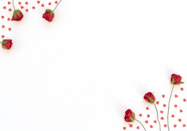 Kırmızı güller ve beyaz arka planda bir sürü küçük kırmızı kalp. Sevgililer Günü, Bahar, doğum günü, düğün, aşk, Anneler Günü konsepti. Selamlar, davetiye. Metin için kopyalama alanı olan düz uzandı.