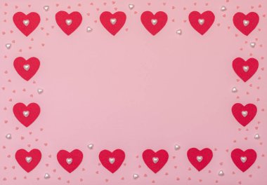 Kırmızı ve inci kalpli sevgililer günü pembe arka planı. Sevgililer Günü tebrik kartı. Düz yatış stili.