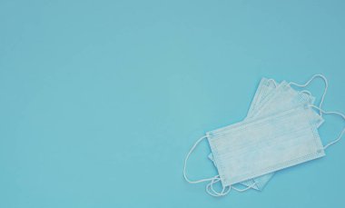 Mavi arka planda açık mavi tıbbi maskeler. Mevsimsel hastalıklar. 