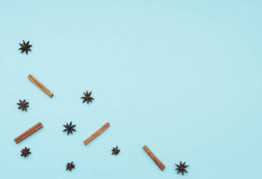 Tarçın çubukları ve anason yıldızları mavi arka planda. Yemek pişirme konsepti. Kış ve tatil baharatları. Düz konum, metin için kopyalama alanı olan üst görünüm. 