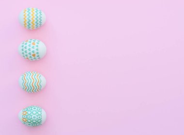 Süslü Paskalya yumurtaları pembe arka planda yatar. Mutlu Paskalya tatili konsepti. Selamlar, davetiye. Kopya alanı ile düz uzanma biçimi.