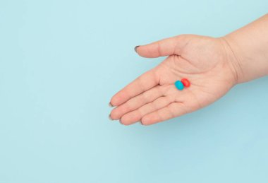 Mavi arka planda kırmızı ve mavi haplar. Doğru seçim kavramı. Kopya alanı ile düz uzanma biçimi.