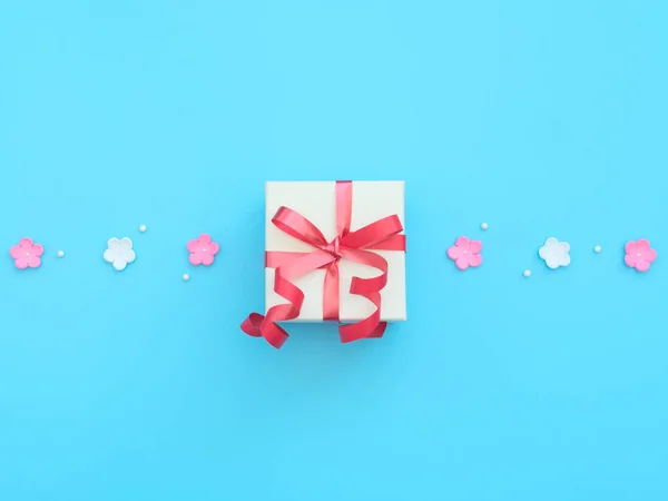 Witte geschenkdoos met rood lint, roze en witte bloemen gemaakt van schuim en kralen op blauwe achtergrond. Moederdag, Valentijnsdag, Bruiloft, Verjaardag concept. Wenskaart of uitnodigingskaart. Vlakke plaat. — Stockfoto