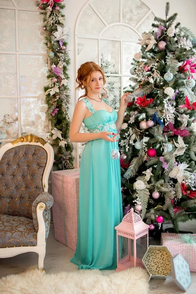 크리스마스 트리 옆에 있는 이브닝 드레스에 여자. 새 해의 이브입니다. 크리스마스. — 스톡 사진
