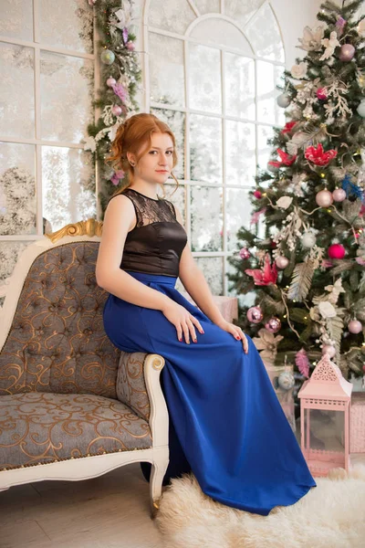 クリスマス ツリーの横にある青いイブニング ドレスの女の子。大晦日。クリスマス. — ストック写真
