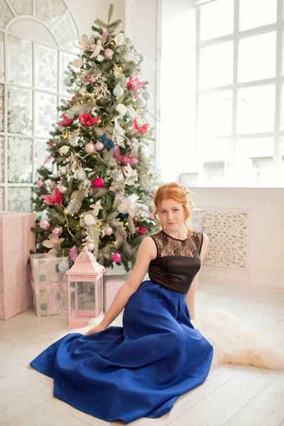 クリスマス ツリーの横にある青いイブニング ドレスの女の子。大晦日。クリスマス. — ストック写真