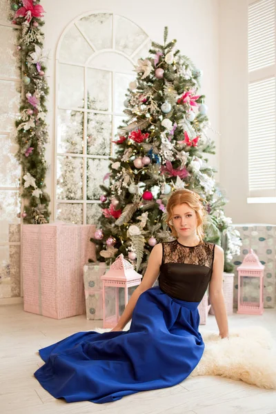 Ein Mädchen im blauen Abendkleid neben einem Weihnachtsbaum. Silvester. Weihnachten. — Stockfoto