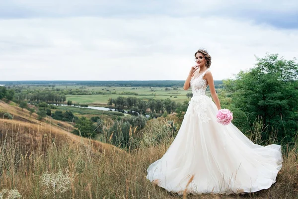 Beautiful young bride girl smiling, standing in wedding dress. — Stock Photo, Image