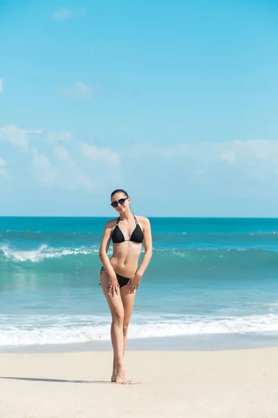 Detail krásné luxusní slim a opálenou dívka v černé Bikiny na pláži oceánu. Sexy opálená těla, ploché břicho, dokonalou postavu. Umístěte na tropickém ostrově. — Stock fotografie