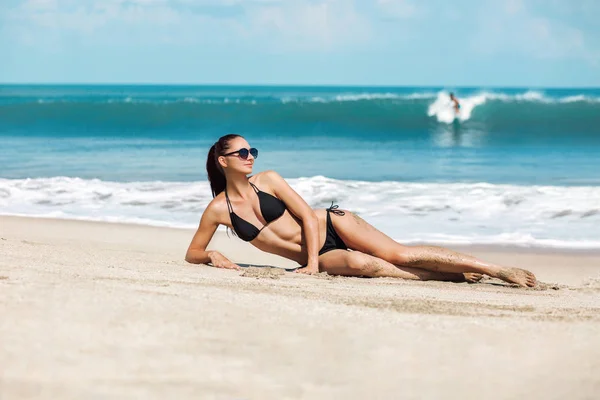 Detail krásné luxusní slim a opálenou dívka v černé Bikiny na pláži oceánu. Sexy opálená těla, ploché břicho, dokonalou postavu. Umístěte na tropickém ostrově. — Stock fotografie