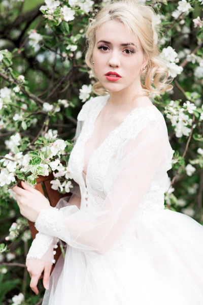Retrato de una joven, la novia en el huerto de manzanas. Joven mujer rubia hermosa en el jardín floreciente. Novia. . — Foto de Stock