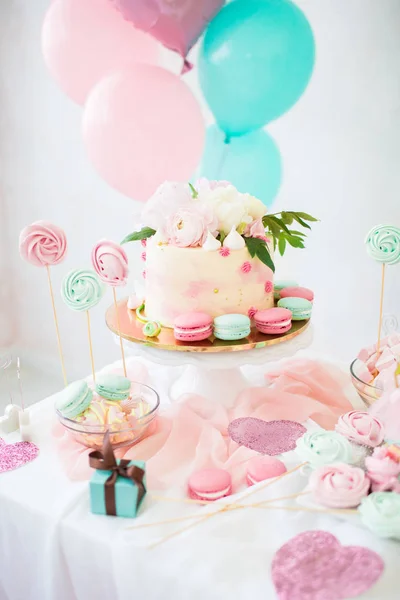 Rosa Kuchen mit frischen Blumen. weiße Hochzeitstorte. farbige Cupcakes und Makkaroni. — Stockfoto